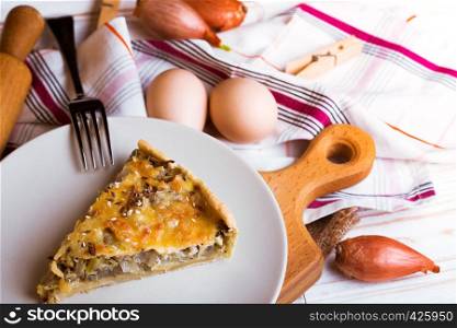 foodphoto - onion pie on a plate, near fork, eggs, onion