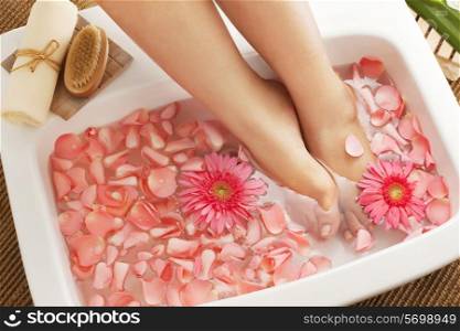 Foot bath in bowl with flower petals