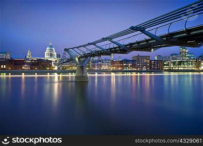 Foot bridge over urban river at night