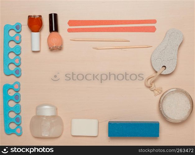 Foot care. Pedicure accessories set tools on wooden board background top view border frame with copy space. Pedicure accessories tools top view