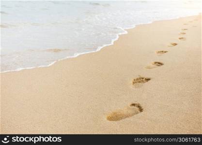 Foot print on sand at the beach background