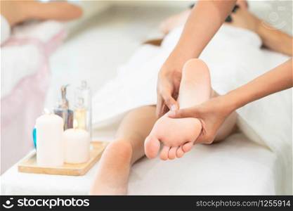 Foot spa massage treatment by professional massage therapist in luxury spa resort. Wellness, stress relief and rejuvenation concept.