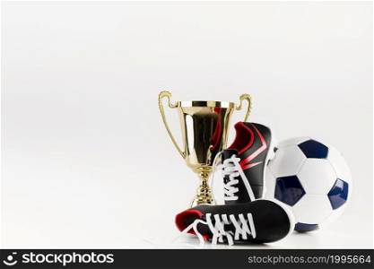 football composition with shoes ball trophy