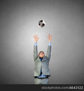 Football fan. Businessman in suit catching soccer ball in jump