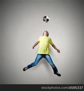 Football fan. Man in casual kick football ball over head