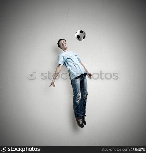 Football fan. Man in casual kick football ball over head