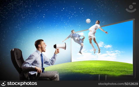 Football fan. Young man screaming in megaphone and watching football match