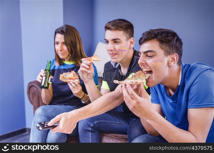 football fans couch eating pizza