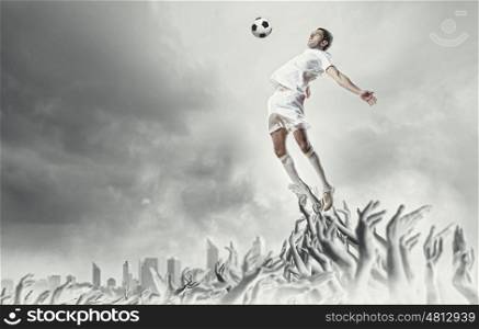 Football fans. Football player in jump kicking the ball