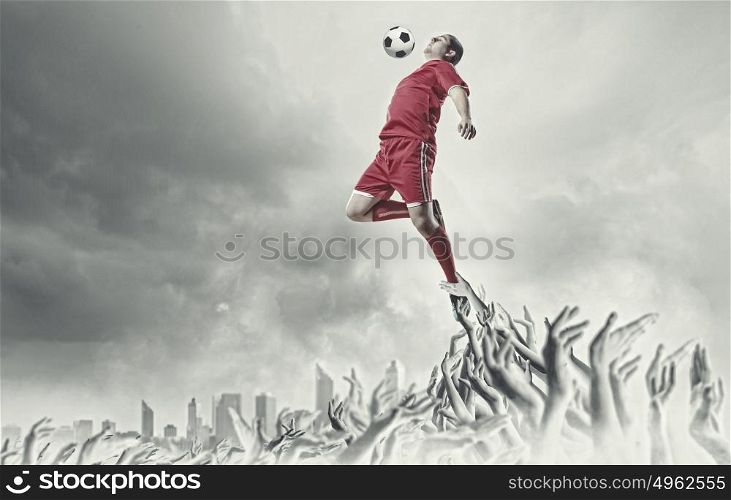 Football fans. Football player in jump kicking the ball