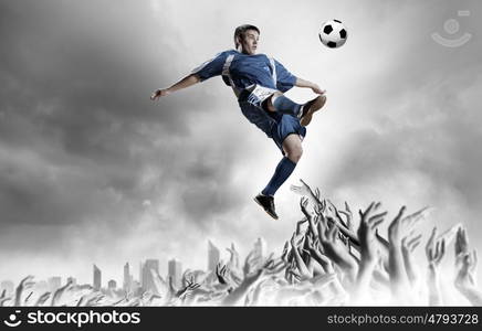 Football fans. Football player in jump kicking the ball supported by fans