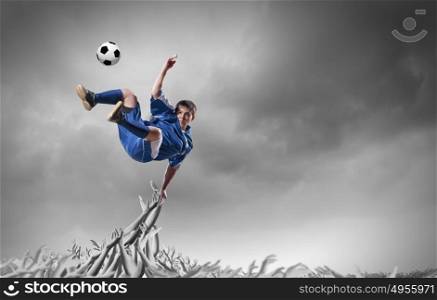 Football fans. Football player in jump kicking the ball supported by fans