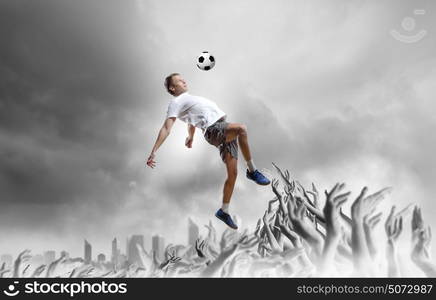 Football fans. Football player in jump kicking the ball supported by fans