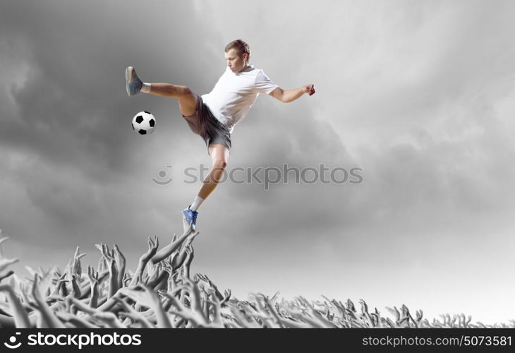 Football fans. Football player in jump kicking the ball supported by fans