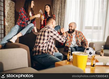 Football fans wathing tv broadcast at home, friends happy for the victory. Group of people cheer for their favorite team, decisive match. Cheerful company celebrate goal. Football fans wathing tv broadcast at home
