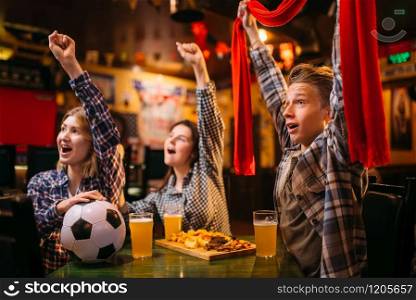 Football fans with scarf watching match and raise their hands up in sports bar. Tv broadcasting, young friends leisures in pub, favorite team wins. Football fans raise their hands up in sports bar