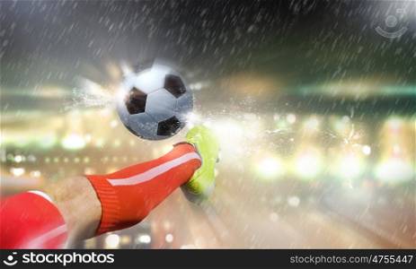 Football game. Close up image of footballer foot kicking the ball