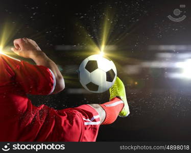 Football game. Close up image of footballer foot kicking the ball
