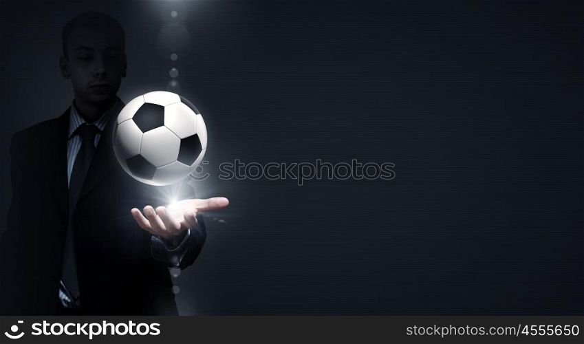 Football game. Close up of elegant businessman holding soccer ball in hand