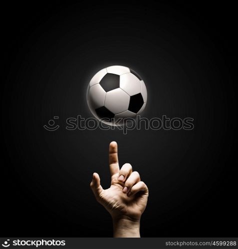 Football game. Close up of man hand pointing at soccer ball