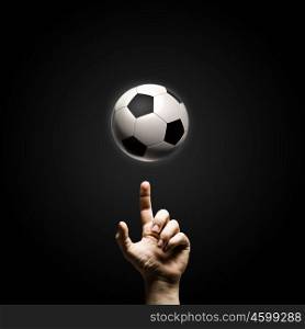 Football game. Close up of man hand pointing at soccer ball