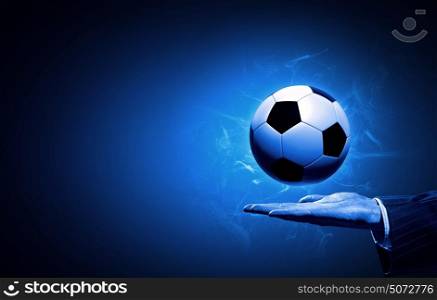 Football game . Football manager hold ball on his hand on blue background