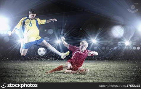 Football game. Two young football players struggling for ball