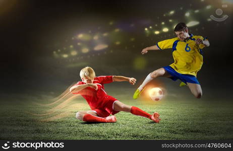 Football game. Two young football players struggling for ball