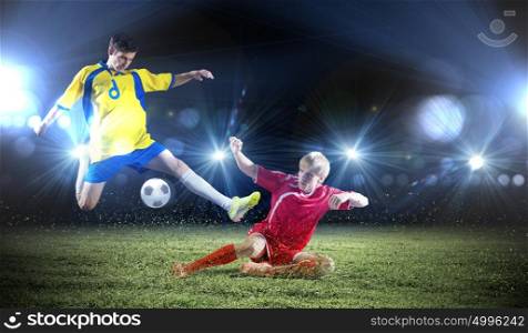 Football game. Two young football players struggling for ball