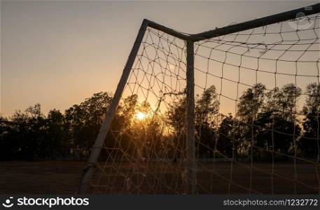 Football goal with sunset light background in the public stadium.