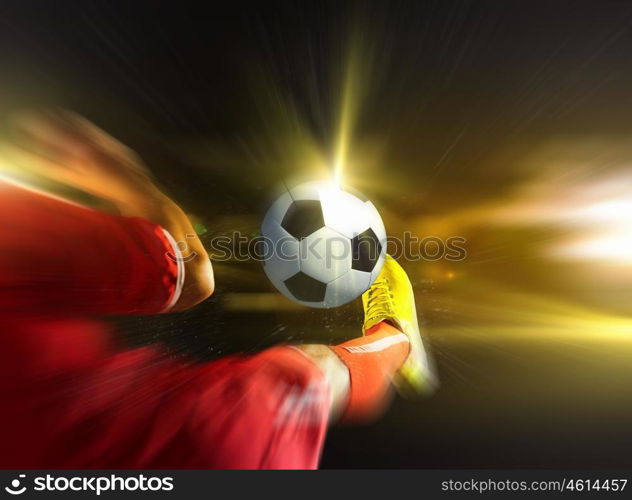 Football kick. Close up image of footballer foot kicking the ball