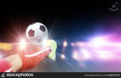 Football kick. Close up image of footballer foot kicking the ball