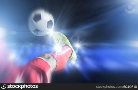 Football kick. Close up image of footballer foot kicking the ball