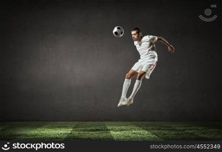Football player. Football player in red shirt jump taking ball
