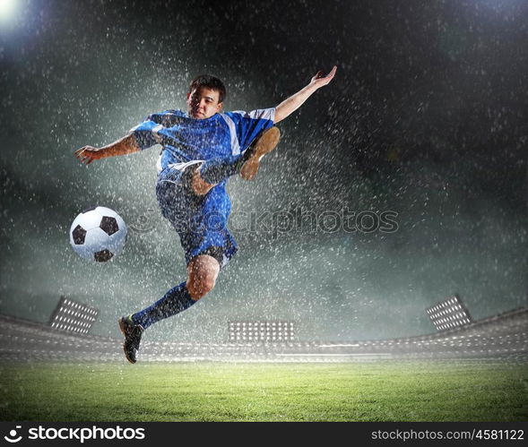 Football player. Image of football player at stadium hitting ball