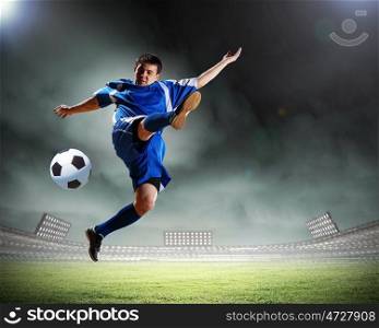 Football player. Image of football player at stadium hitting ball