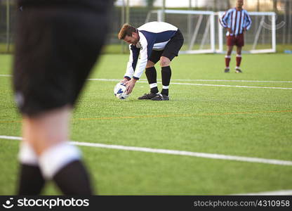 Football player positioning ball