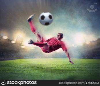 football player striking the ball. football player in red shirt striking the ball at the stadium