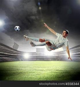 football player striking the ball. football player in white shirt striking the ball at the stadium