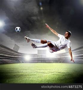 football player striking the ball. football player in white shirt striking the ball at the stadium