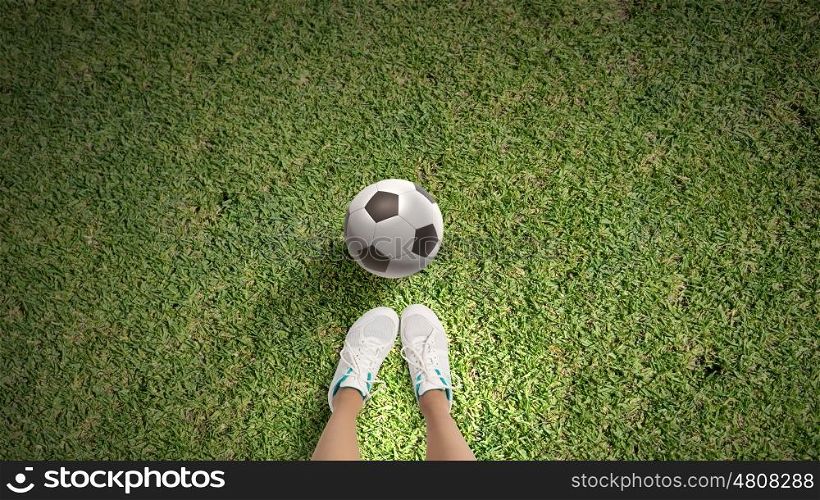 Football player. Top view of female football player on green grass