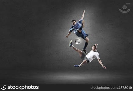 Football player. Two football players in jump fighting for ball