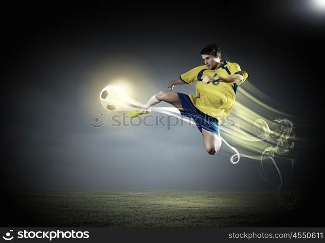 Football player. Young football player on stadium in jump taking ball