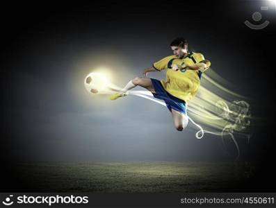Football player. Young football player on stadium in jump taking ball