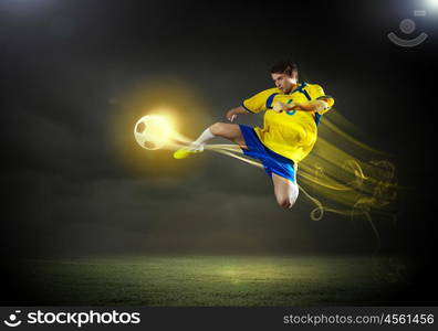 Football player. Young football player on stadium in jump taking ball