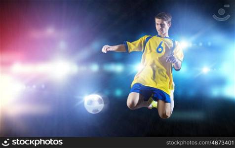 Football player. Young football player on stadium in jump taking ball