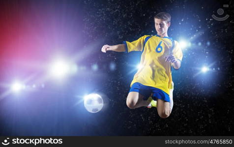 Football player. Young football player on stadium in jump taking ball