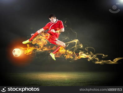 Football player. Young football player on stadium in jump taking ball