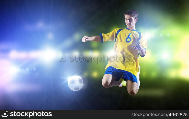 Football player. Young football player on stadium in jump taking ball