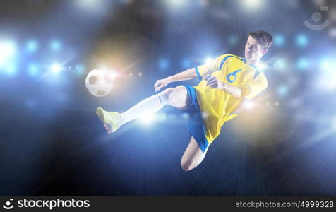 Football player. Young football player on stadium in jump taking ball